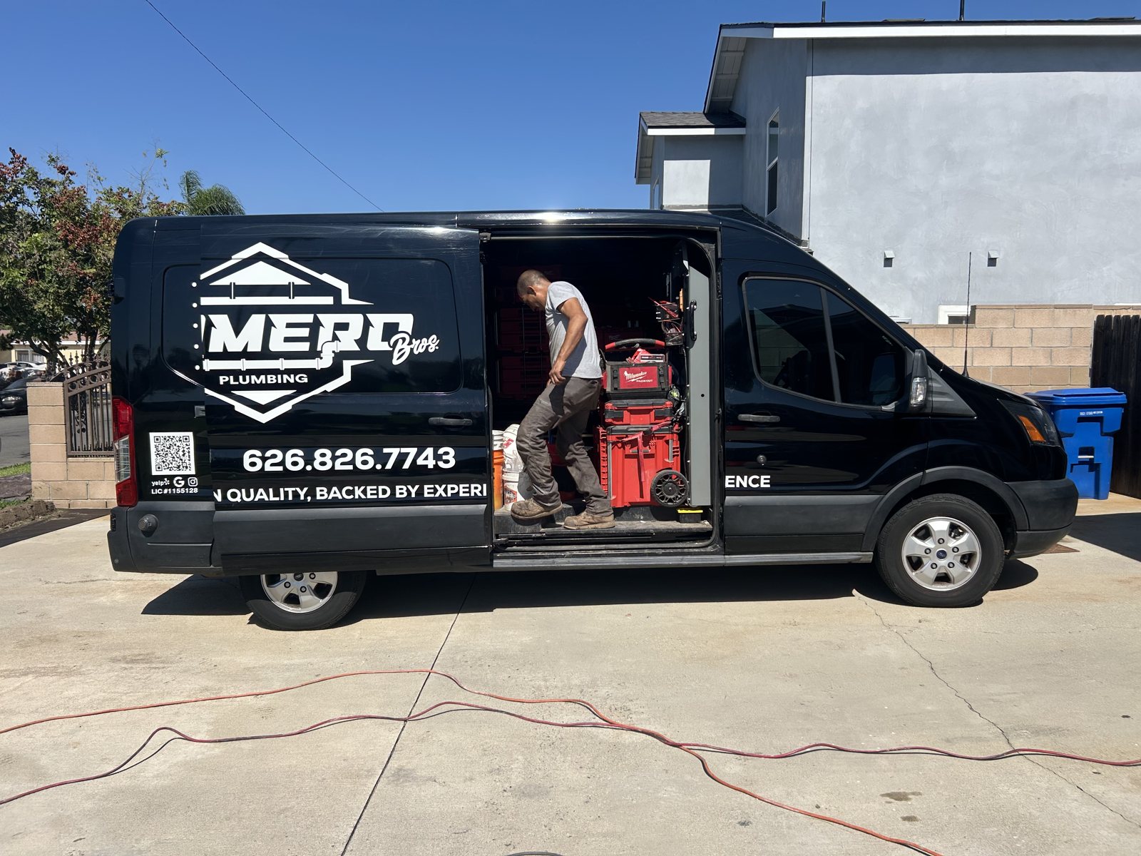 Vicente at the open Romero Bros Plumbing van with equipment